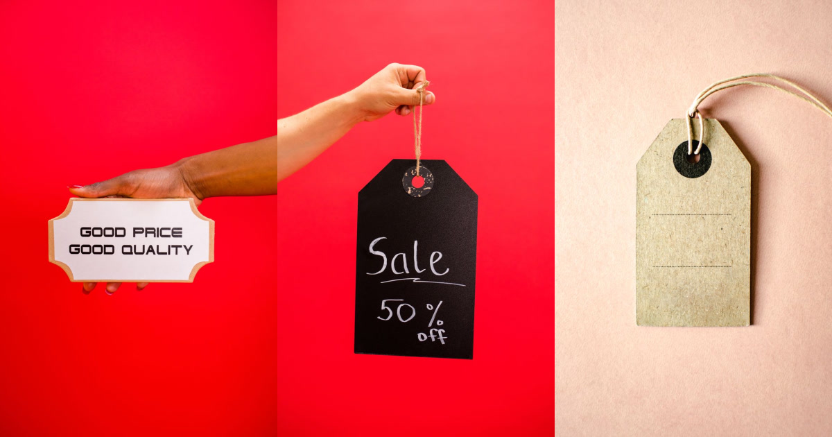 Three hands holding up price tags, two on a red background and one on a pink background.